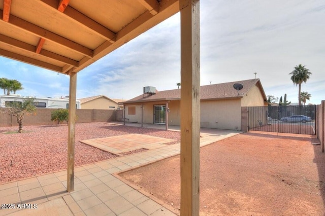 rear view of house with central air condition unit, a patio area, a fenced backyard, and stucco siding