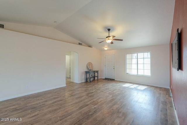 spare room with arched walkways, lofted ceiling, wood finished floors, a ceiling fan, and visible vents