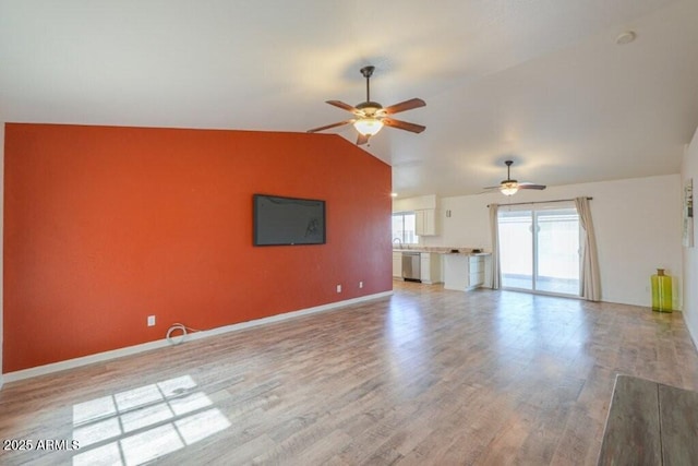 unfurnished living room featuring lofted ceiling, ceiling fan, baseboards, and wood finished floors