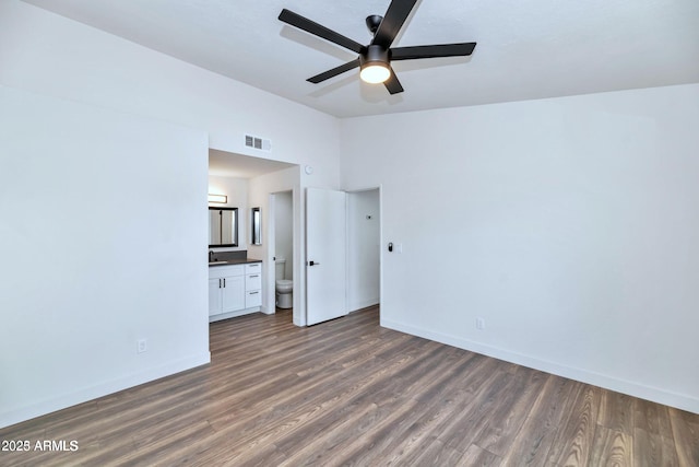 unfurnished bedroom featuring lofted ceiling, visible vents, baseboards, and dark wood-style flooring