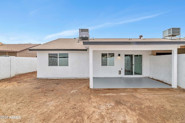 rear view of house with central air condition unit, a patio area, fence, and stucco siding