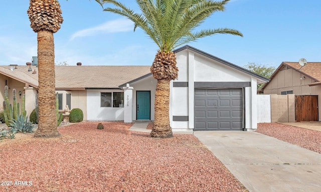 view of front of house with concrete driveway, fence, an attached garage, and stucco siding