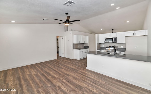 kitchen featuring dark countertops, visible vents, appliances with stainless steel finishes, white cabinets, and a sink