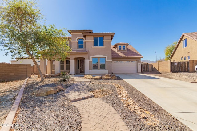 mediterranean / spanish house featuring an attached garage, fence, a tile roof, concrete driveway, and stucco siding