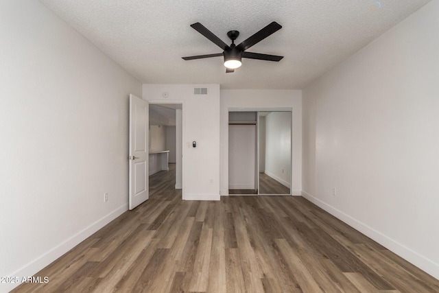 unfurnished bedroom featuring a closet, dark wood finished floors, visible vents, and baseboards