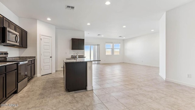 11891 E Cliffrose Ln, Florence, AZ 85132 - kitchen with stainless steel appliances, light stone counters, recessed lighting, light tile patterned flooring, and dark brown cabinets