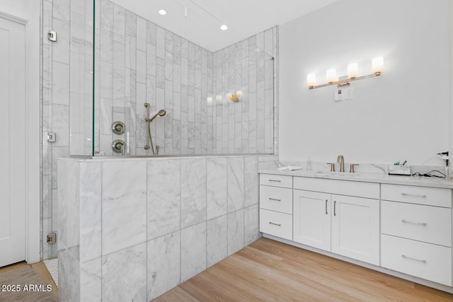 full bath featuring tile walls, recessed lighting, a shower stall, vanity, and wood finished floors