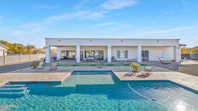 rear view of property featuring a patio, fence, a ceiling fan, and a fenced in pool