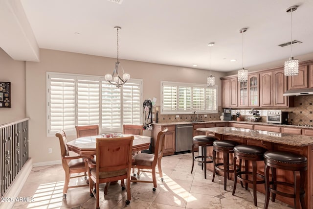 dining space featuring a notable chandelier and sink