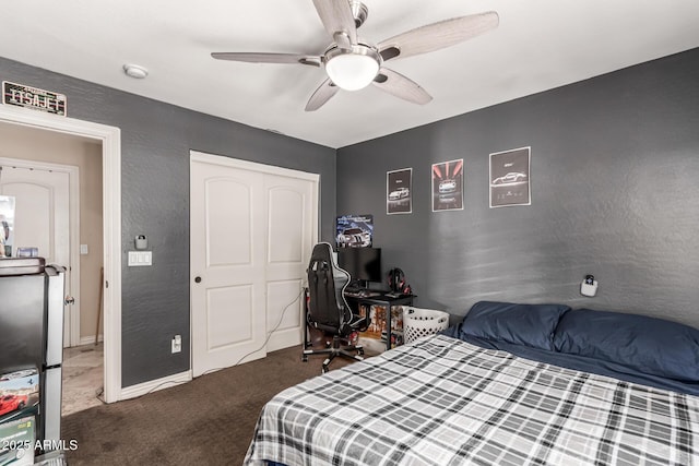 carpeted bedroom featuring ceiling fan and a closet