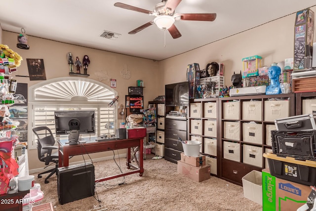 carpeted office space featuring ceiling fan