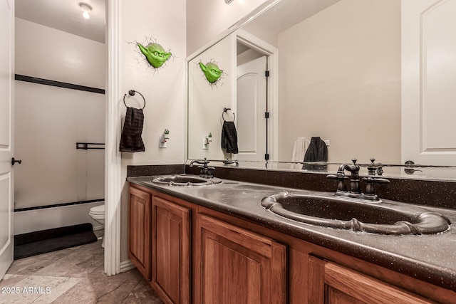 full bathroom with bath / shower combo with glass door, vanity, and toilet