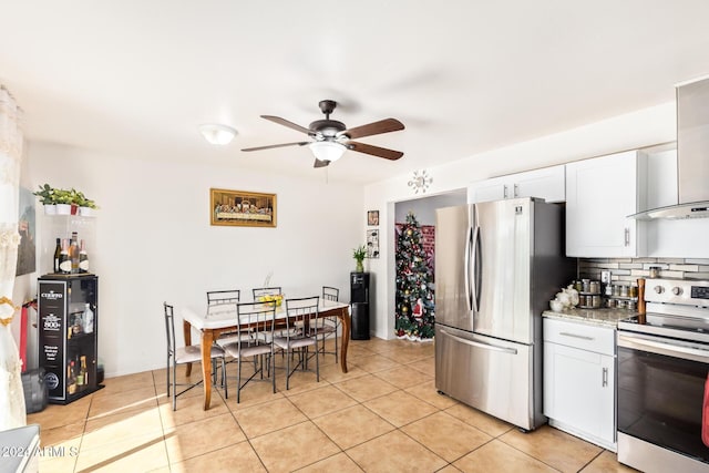 kitchen with white cabinetry, light tile patterned flooring, stainless steel appliances, and light stone counters