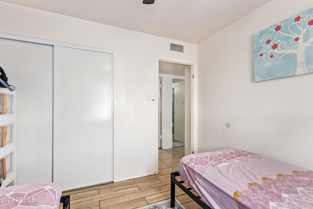 bedroom with hardwood / wood-style floors, a closet, and ceiling fan