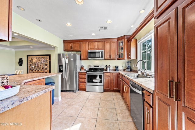 kitchen with ornamental molding, sink, light tile patterned floors, and stainless steel appliances