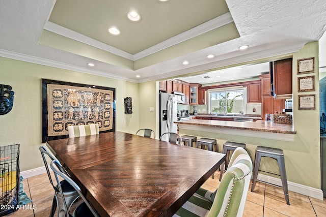 tiled dining area featuring ornamental molding and sink