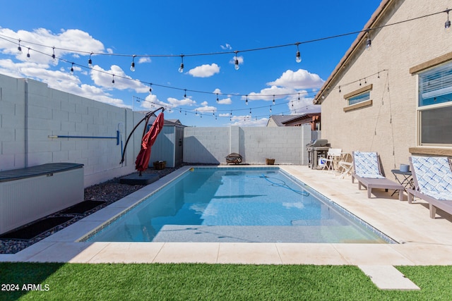 view of swimming pool with area for grilling and a patio