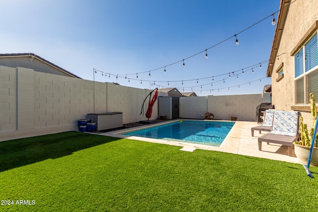 view of swimming pool featuring a patio area, grilling area, and a lawn