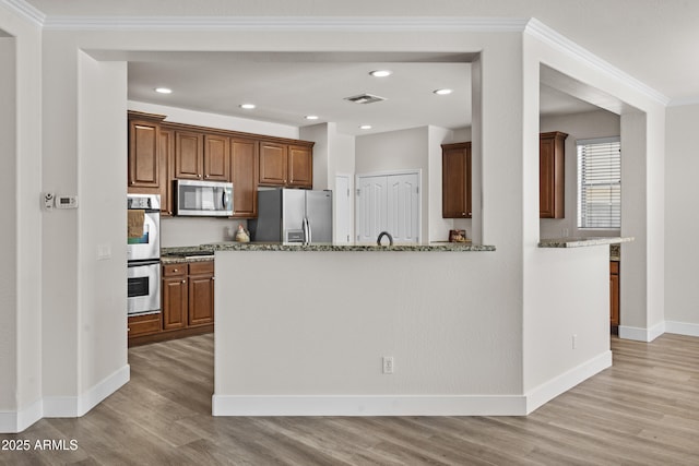 3575 E Gary Way, Gilbert, AZ 85234 - kitchen featuring appliances with stainless steel finishes, light wood finished floors, dark stone counters, ornamental molding, and recessed lighting