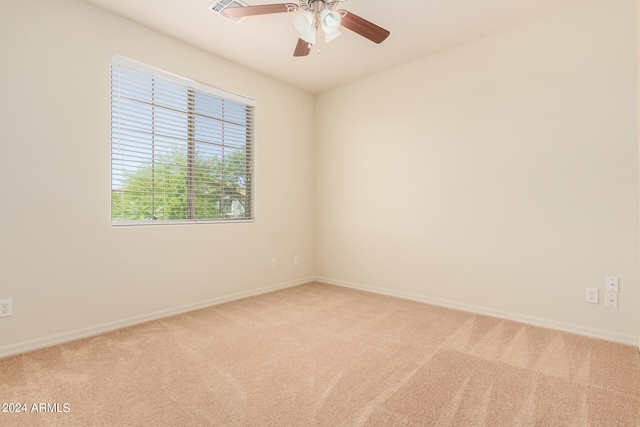 carpeted spare room featuring ceiling fan