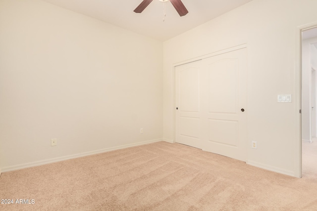 unfurnished bedroom with a closet, carpet floors, and ceiling fan