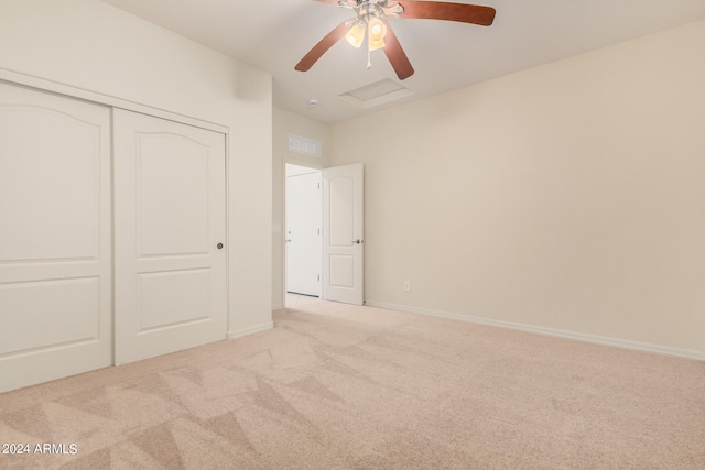 unfurnished bedroom with light colored carpet, ceiling fan, and a closet