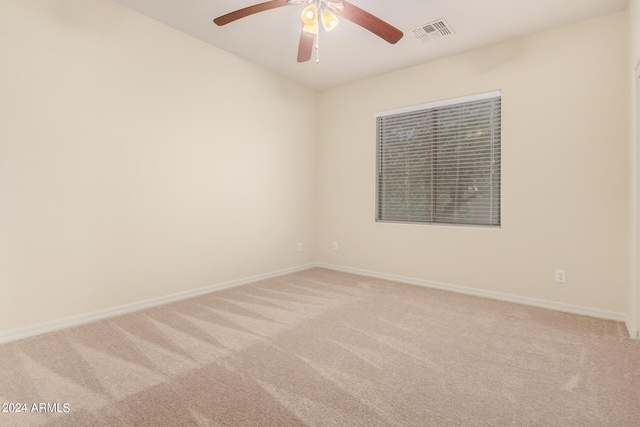 carpeted spare room with ceiling fan