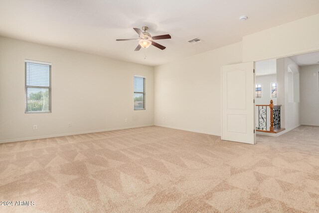 carpeted empty room featuring a healthy amount of sunlight and ceiling fan