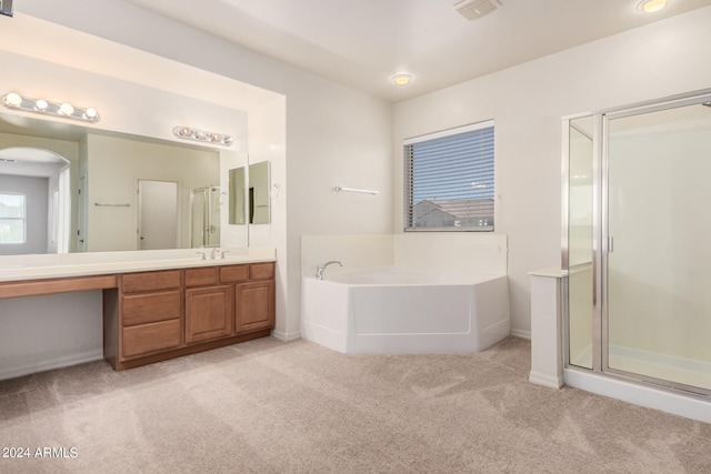 bathroom with independent shower and bath and vanity