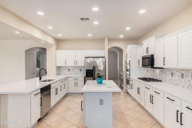 kitchen with a kitchen island, tasteful backsplash, sink, and stainless steel appliances