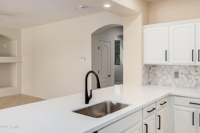 kitchen with sink, tasteful backsplash, white cabinetry, and light tile floors