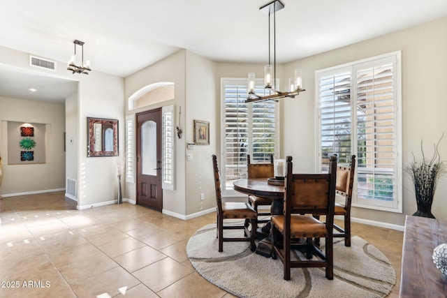 tiled dining room featuring a chandelier