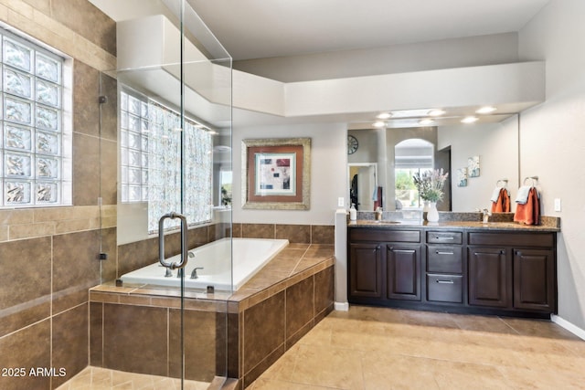 bathroom featuring plus walk in shower, tile patterned floors, and vanity