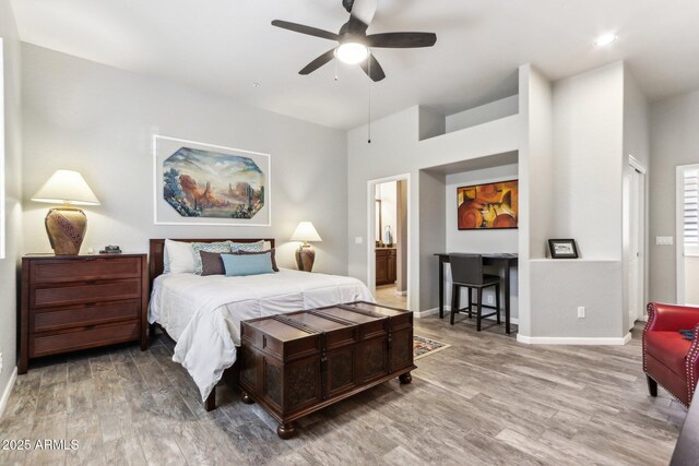 bedroom with wood-type flooring, connected bathroom, and ceiling fan