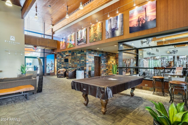 game room with a towering ceiling, carpet floors, and billiards