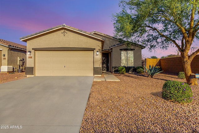 single story home with a garage, a tile roof, fence, concrete driveway, and stucco siding