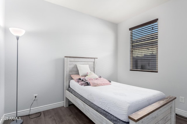 bedroom featuring baseboards and dark wood-type flooring