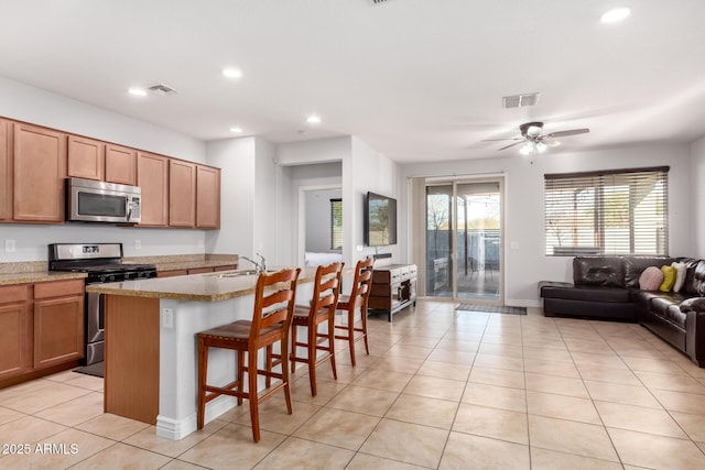 kitchen with appliances with stainless steel finishes, open floor plan, visible vents, and light tile patterned floors