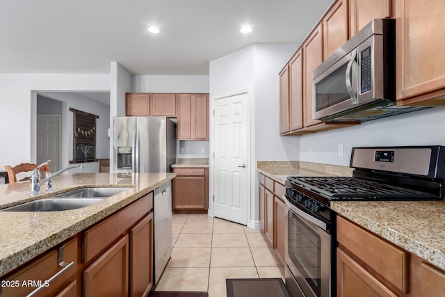 kitchen featuring light tile patterned floors, stainless steel appliances, recessed lighting, a sink, and light stone countertops