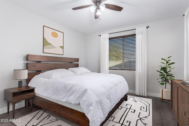 bedroom with a ceiling fan, baseboards, and wood finished floors