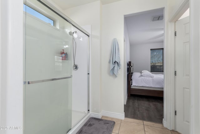 ensuite bathroom with ensuite bathroom, a stall shower, tile patterned flooring, and visible vents