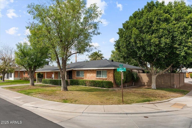 ranch-style house with a front yard and fence