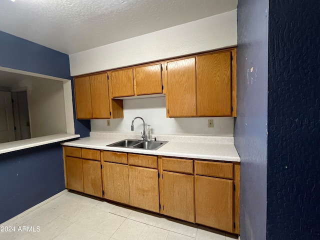 kitchen featuring a textured ceiling and sink