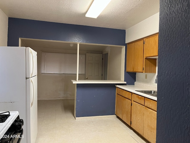 kitchen with sink, a textured ceiling, and white appliances