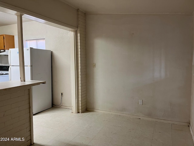 interior space with white fridge and range hood