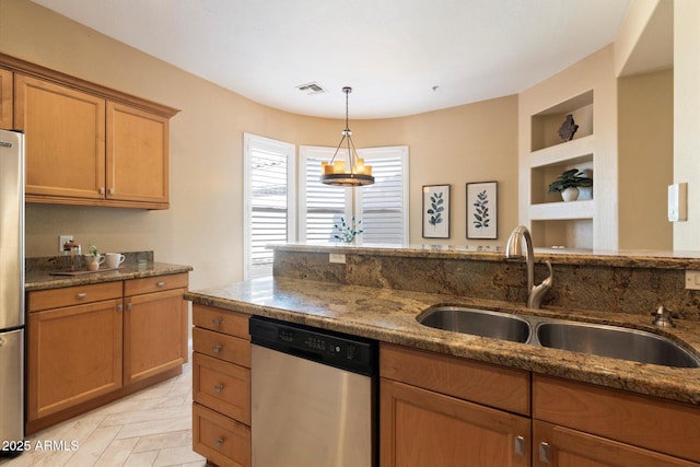 kitchen with light parquet floors, sink, built in shelves, dark stone countertops, and appliances with stainless steel finishes