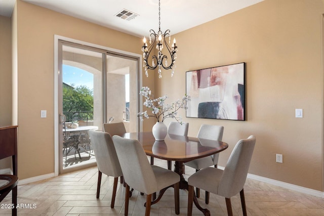 dining room featuring light parquet flooring and a chandelier