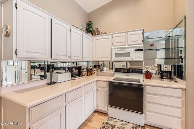 kitchen with white cabinetry, white microwave, and range with electric cooktop