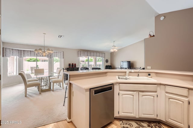 kitchen featuring a sink, open floor plan, light countertops, dishwasher, and vaulted ceiling