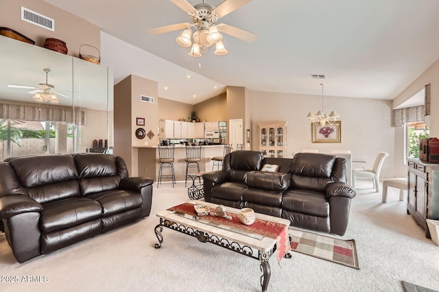 living room featuring visible vents, light carpet, vaulted ceiling, and ceiling fan with notable chandelier